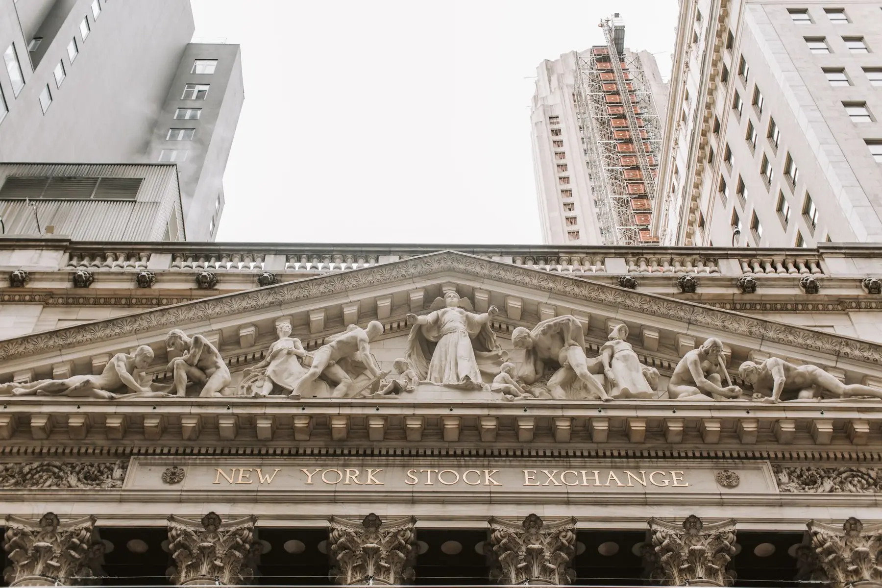 Detailed view of the New York Stock Exchange facade featuring neoclassical sculptures and signage