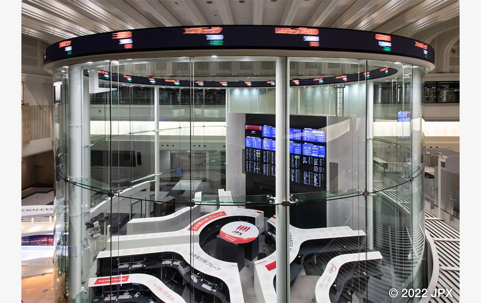 Interior view of the Tokyo Stock Exchange featuring the JPX logo and digital stock tickers