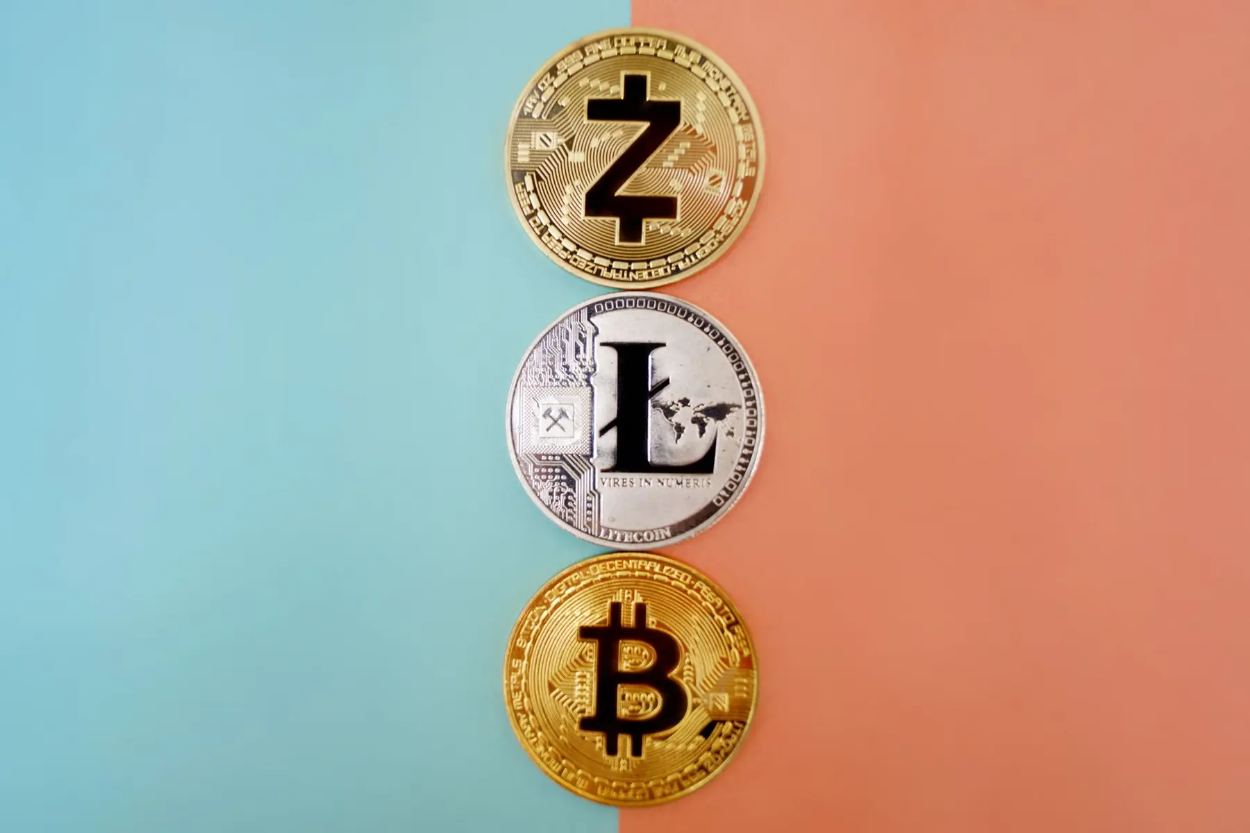 Three cryptocurrency coins featuring Zcash, Litecoin, and Bitcoin symbols arranged vertically on a split blue and orange background